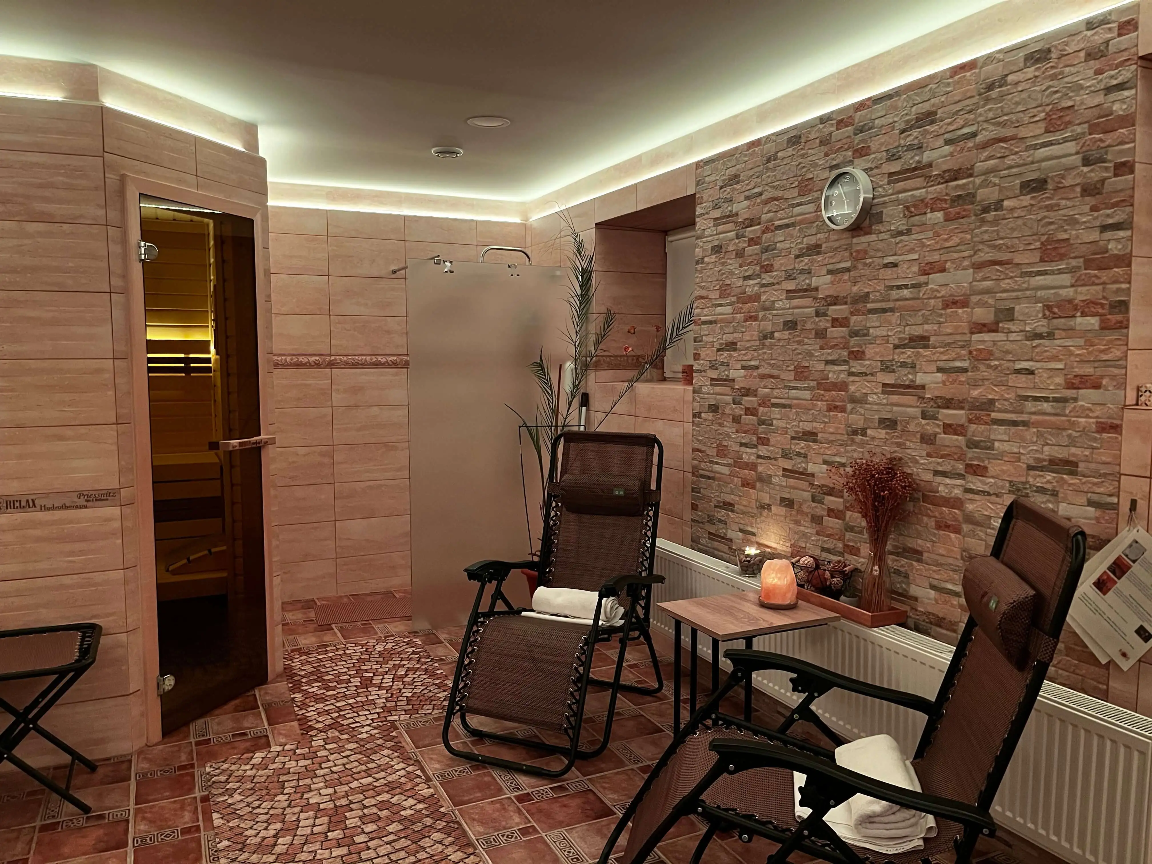 Privátní wellness se záběrem na saunu a relaxační posezení ve světlém osvětlení.