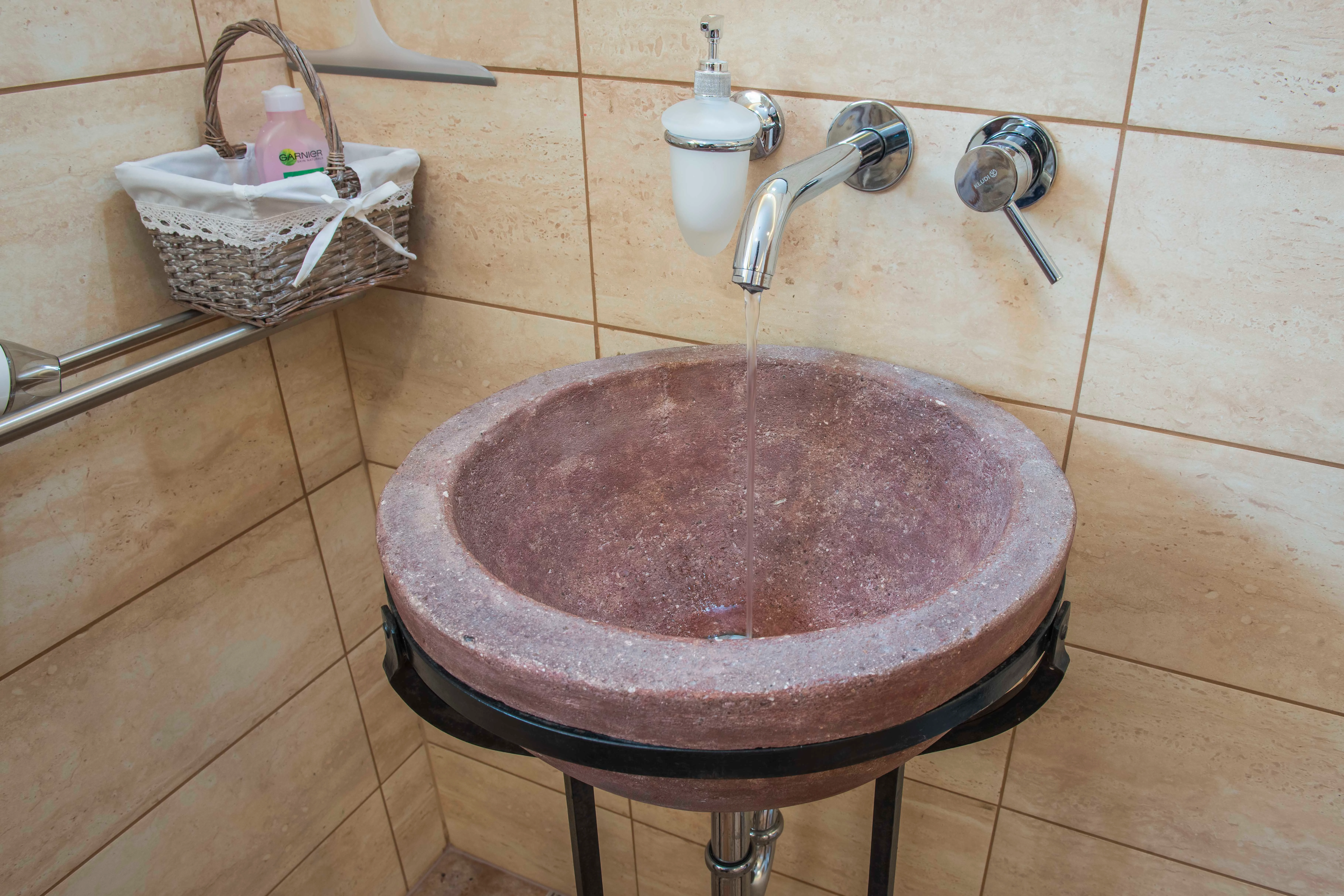 Kamenné ozdobné umyvadlo s květinovou dekorací.